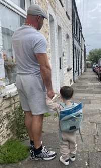 FRED Father and Son Walking Together with Book in Bag