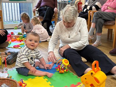 Care residents playing with baby at stay and play session