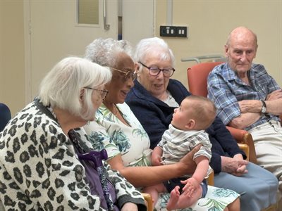 Care home residents playing with a young child at the play session