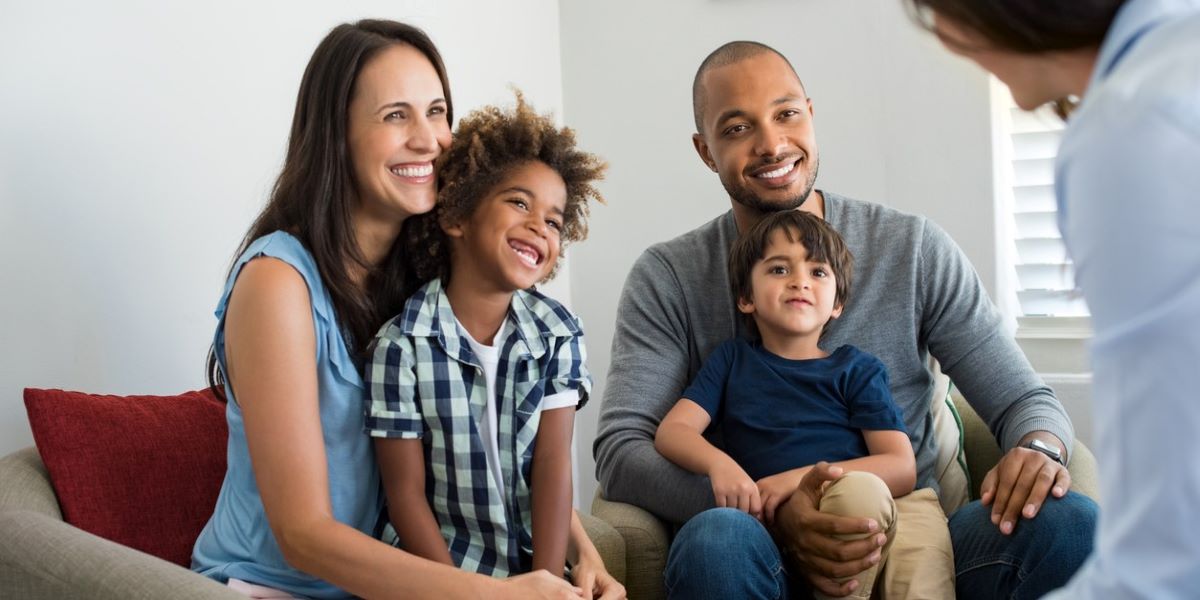 Smiling family sitting and talking with counsellor